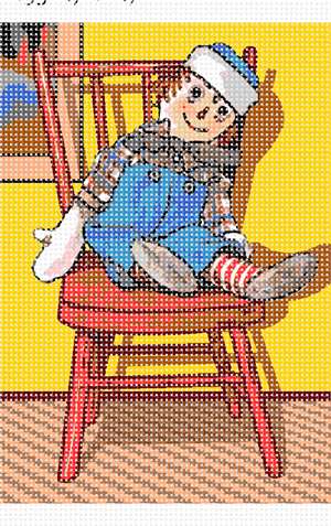 The well-known rag doll, sitting handsomely in a wicker chair.