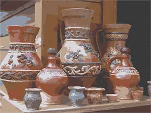A collection of ceramic vases, pitchers, and cups on display.
